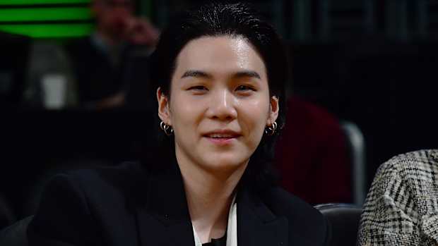 Suga smiles for a picture.